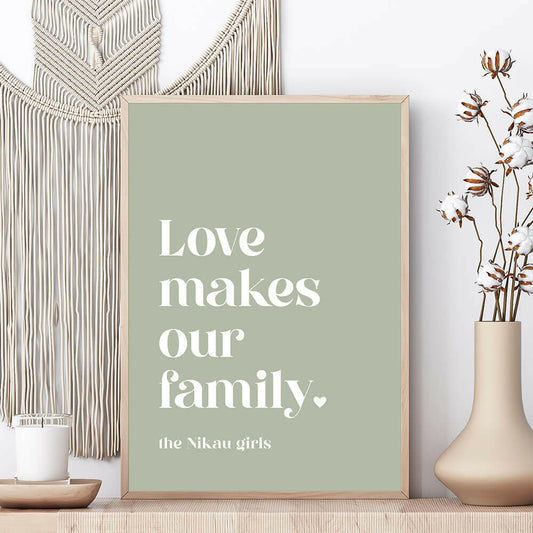 Love Makes Our Family personalised family print in sage framed on shelf with vase beside and macrame wall hanging behind, by Paper Heart Design NZ
