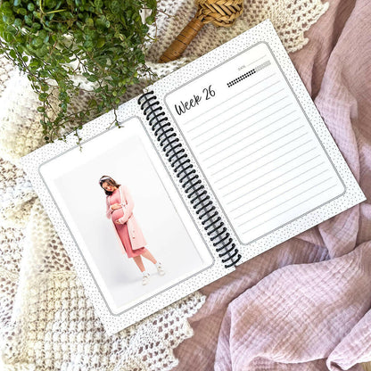 Bump to Bubba pregnancy journal open to week 26 pages flat lay with pregnant lady and plant in background, by Paper Heart Design
