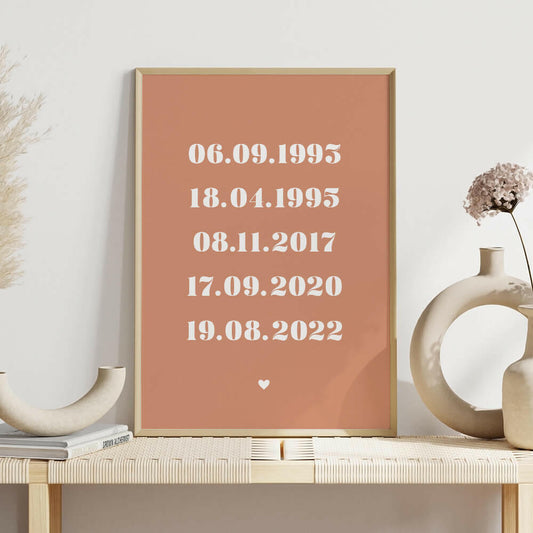 Family Dates personalised print framed in clay with white bold serif font on shelf with white vases, family wall art by Paper Heart Design