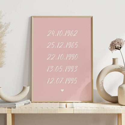 Family Dates personalised print framed in pink with white brush script font on shelf with white vases, family wall art by Paper Heart Design