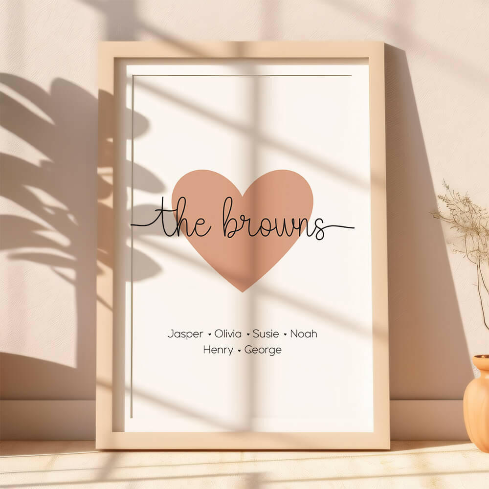 Family Script personalised family name print with clay heart icon and black script font, lifestyle image with plant shadows, by Paper Heart Design