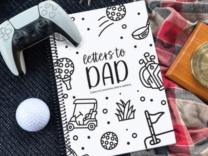 Letters to Dad keepsake book with golf cover on navy knit and red plaid surface with white golf ball, wooden barometer and white PlayStation controller, gift for Dad by Paper Heart Design NZ