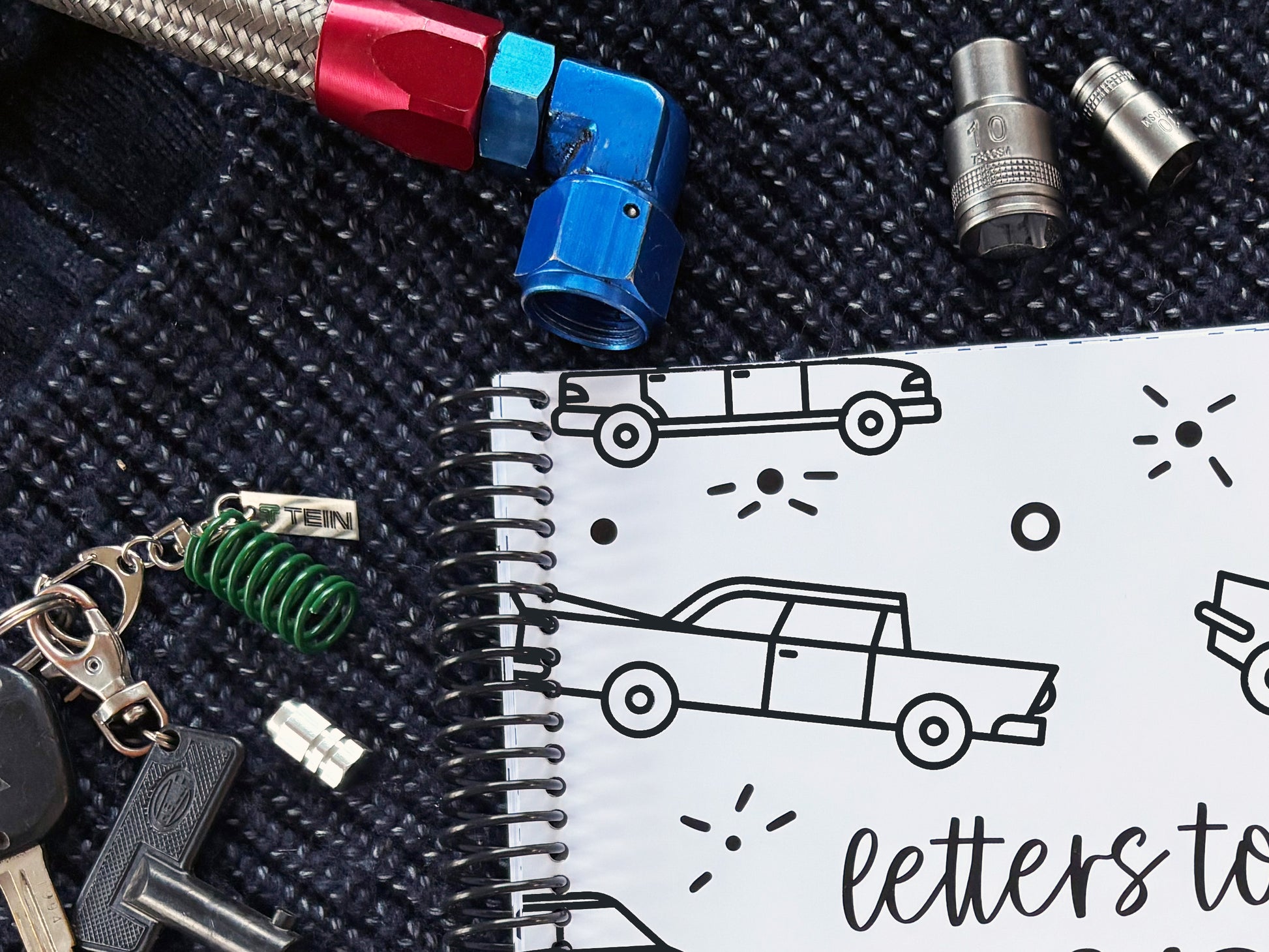 Letters to Dad keepsake book vehicles cover close up showing spiral binding detail with 10mm socket, car keys and AN hose fitting, by Paper Heart Design NZ