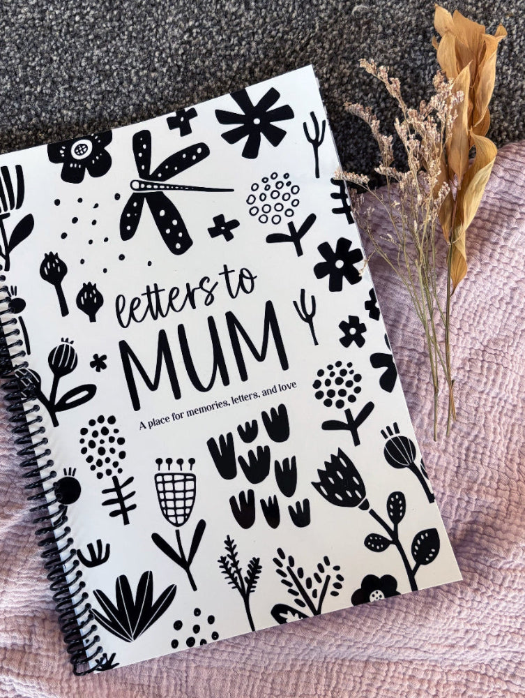 Letters to Mum keepsake book black and white cover flat lay on grey carpet with pink fabric and dried flowers, by Paper Heart Design NZ