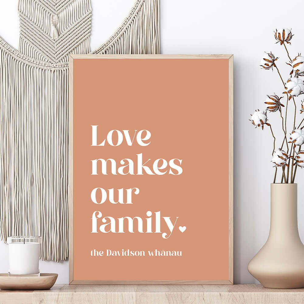 Love Makes Our Family personalised family print in clay framed on shelf with vase beside and macrame wall hanging behind, by Paper Heart Design NZ