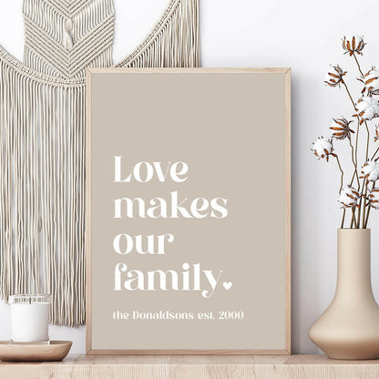 Love Makes Our Family personalised family print in pebble framed on shelf with vase and candle beside and macrame wall hanging behind, by Paper Heart Design NZ