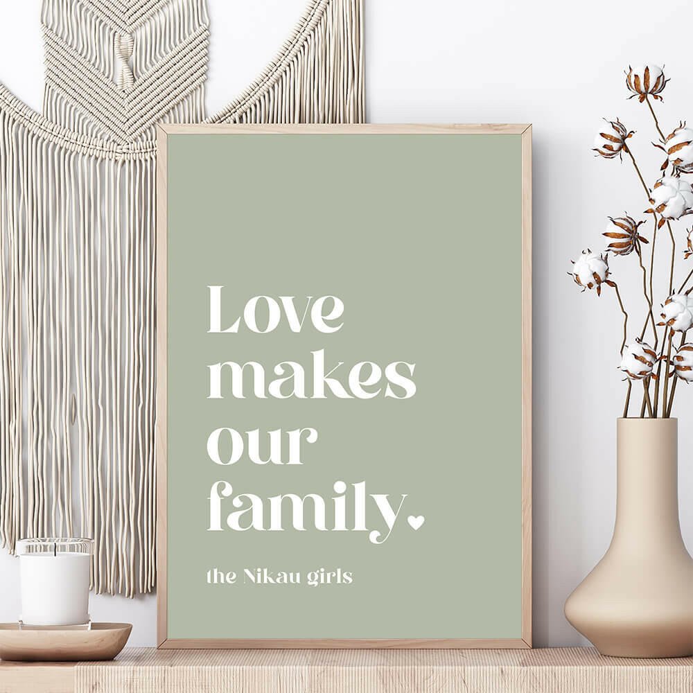 Love Makes Our Family personalised family print in sage framed on shelf with vase beside and macrame wall hanging behind, by Paper Heart Design NZ
