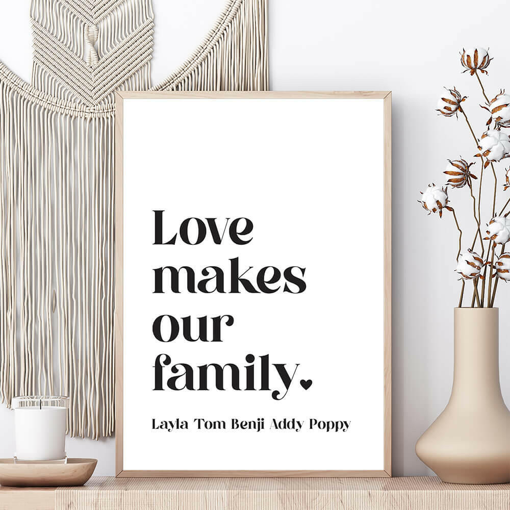 Love Makes Our Family personalised family print in white with black text framed on shelf with vase and candle beside and macrame wall hanging behind, by Paper Heart Design NZ