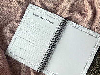 Our Grand Story grandparent keepsake book open to Holidays and Celebrations prompt page and photo space page flat lay on pink fabric, by Paper Heart Design NZ