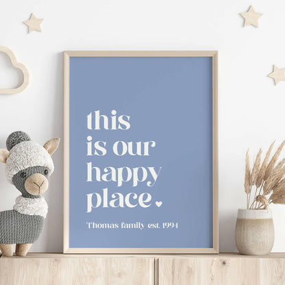 This Is Our Happy Place personalised family print in cornflower framed on shelf with llama stuffed toy, wooden stars on wall and vase with dried plant, by Paper Heart Design NZ
