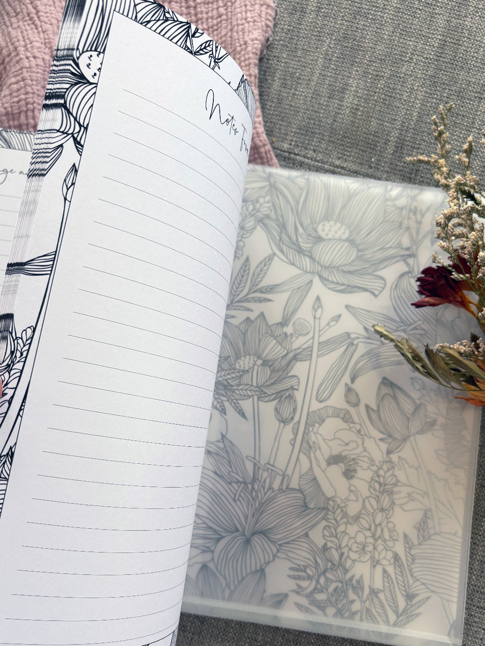 You and Me wedding guest book partially open showing thickness and back pocket for cards and mementos with floral back cover on pink and grey fabric, by Paper Heart Design NZ