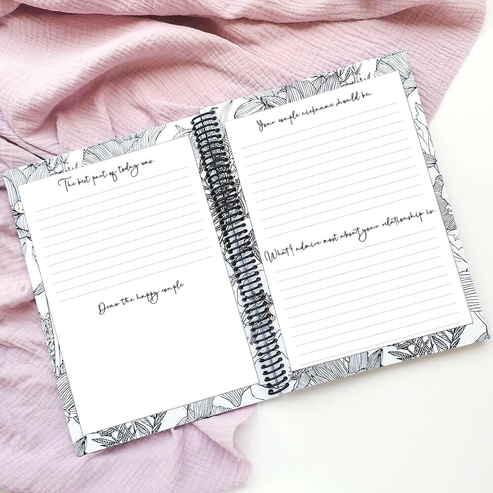 You and Me wedding guest book open to lined pages with guest prompts on pink fabric background, by Paper Heart Design NZ
