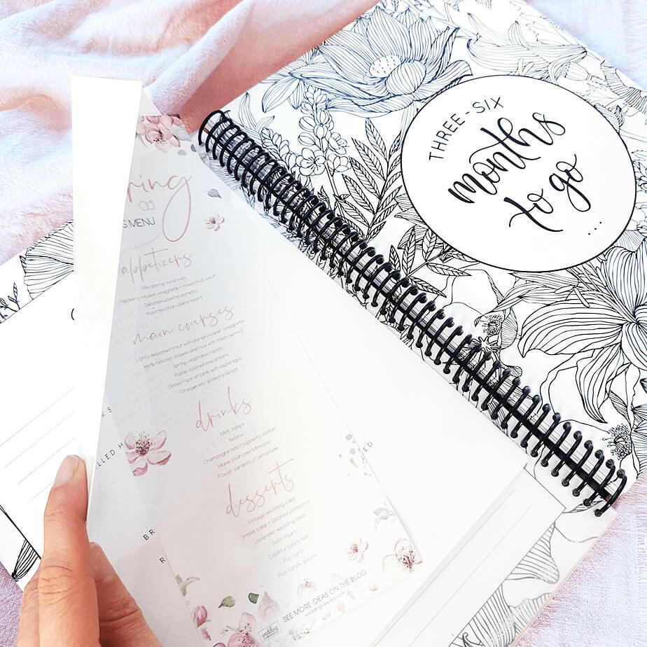You and Me wedding planner held open showing pocket with sample menu and 3 to 6 months section cover page, NZ wedding keepsake by Paper Heart Design