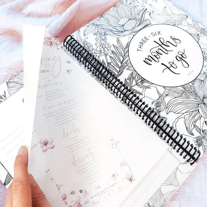 You and Me wedding planner held open showing pocket with sample menu and 3 to 6 months section cover page, NZ wedding keepsake by Paper Heart Design