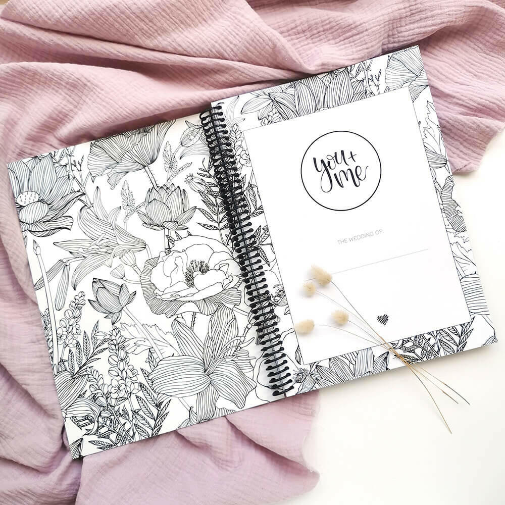 You and Me wedding planner open to title page showing floral inner cover with dried bunny tails on pink textured background, by Paper Heart Design NZ